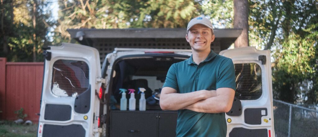 Smiling detailer stands in front of his mobile detailing van in North Seattle.